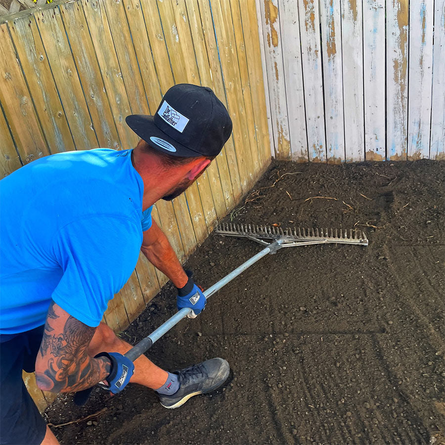 Landscaper prepping and raking before installing fresh sod